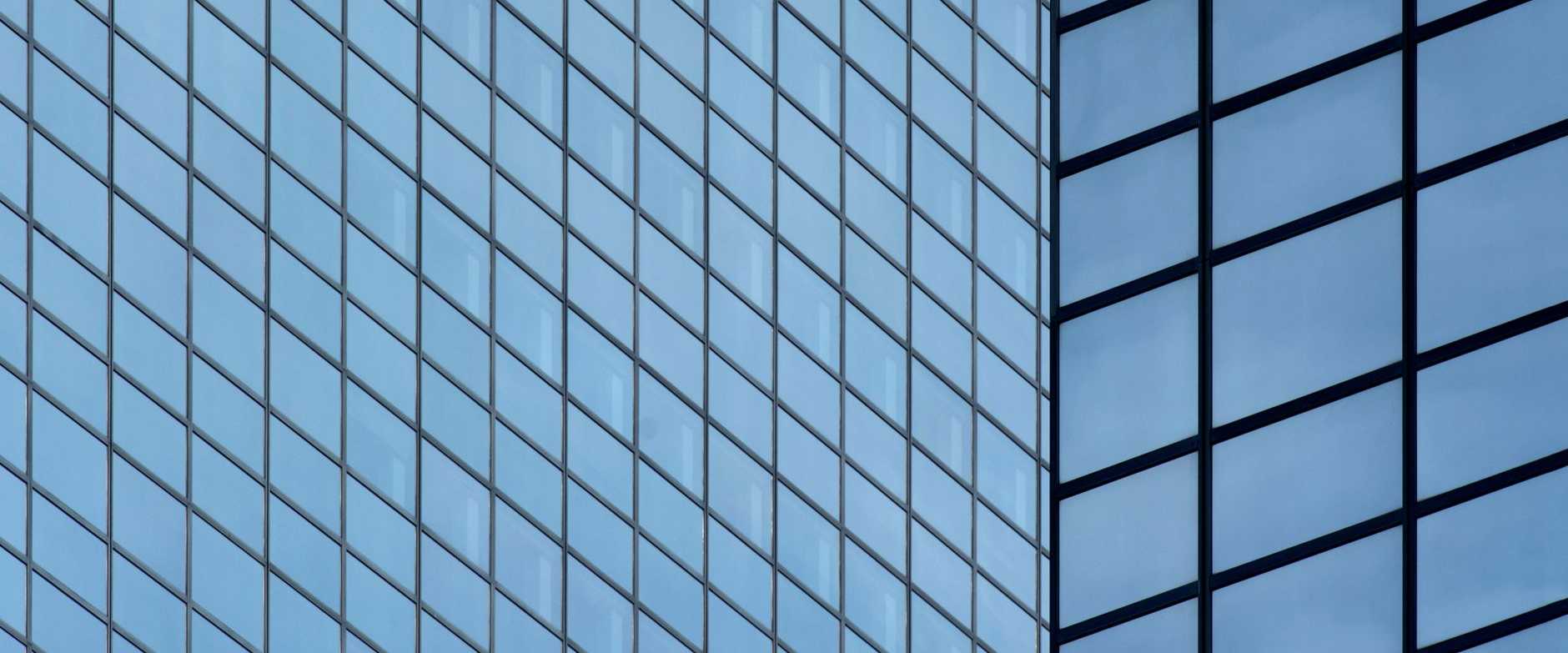 Detaillierte Ansicht der modernen Glassfassade eines Wolkenkratzers, die Wiederholung und Stadtarchitektur zeigt.